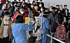 Quarantine officials help travelers from China get compulsory PCR tests for the coronavirus on Monday at Incheon International Airport. [YONHAP]