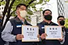 Members of the SsangYong Motor labor union hold up a petition submitted to the Korea Exchange in Yeouido, western Seoul, requesting the exchange operator extend the grace period before declares it delisting. The Korea Exchange has until May 17 to make the final decision. [YONHAP]