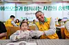Refiner S-Oil CEO Anwar A. Al-Hejazi holds a songpyeon (traditional half-moon-shaped rice cake) with a child at the company's charity event.[S-OIL]