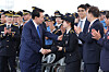 President Yoon Suk Yeol, left, shakes hands with inspector Cho Hyun-jin of the Korea Coast Guard, daughter of the late high-ranking inspector Cho Dong-su, who was honored for his work on policing illegal Chinese fishing boats in the Korean waters off the coast of Incheon in October 2016, at the special commemoration of the 70th anniversary of Day of Korea Coast Guard on Monday in Seo District, Incheon. [YONHAP]