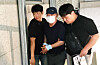 A 79-year-old suspect surnamed Kim, center, who is accused of planting an improvised explosive device in front of a dental clinic in Gwangju on Thursday, is escorted by police officers after his arrest in the city on the same day. [NEWS1]