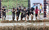 Visitors to the Boryeong Mud Festival in South Chungcheong try a 'Tough Mudder' obstacle course on Saturday. [NEWS1]