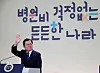 President Moon Jae-in waves his hand at participants in the virtual event to commemorate the fourth year since the introduction of Mooncare, a policy of lowering medical costs for the general public, at the Blue House on Thursday. [JOINT PRESS CORPS]