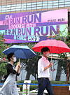 Pedestrians walk past a billboard covered in lyrics from K-pop boy band BTS on Monday, in Gwanghwamun, central Seoul. Kyobo Life Insurance which owns and manages the billboard said it decorated it with lyrics from BTS's song 'Run' (2015) to cheer up people exhausted from the prolonged pandemic. [NEWS1]