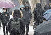 Commuters walk near Hyehwa Station in central Seoul as heavy snow falls in the area on Tuesday morning. [YONHAP]