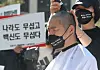 A man whose relative died after getting a Covid-19 vaccine has his head shaved at a press conference as he filed a petition with the Constitutional Court in Seoul on Thursday. An association of family members of Covid-19 vaccination victims demanded compensation from the government in the petition. [NEWS1]