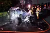 Firefighters extinguish a fire from a BMW that was completely burned after crashing into a trailer in Gwangsan District, Gwangju, on Sunday. [GWANGJU GWANGSAN FIRE STATION]