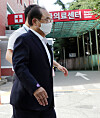 Former Busan Mayor Oh Keo-don is beingtaken to an emergency room at a hospital in Busan on Tuesday. Oh complained offeeling something pressing on his chest while waiting in a police lock-up for acourt’s decision on a detention warrant against him on a charge of sexuallymolesting a female civil servant. [YONHAP]