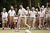 Tom Kim and the International Team celebrate his hole-winning putt to win match 1 with teammate Kim Si-woo against Patrick Cantlay and Xander Schauffele of the United States during Saturday afternoon four-ball matches on day three of the 2022 Presidents Cup in Charlotte, North Carolina on Sept. 24, 2022. [GETTY IMAGES]