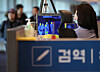 A disease control official monitors thermal footage of passengers who have arrived at Incheon International Airport in this stock photo from 2019. [YONHAP]