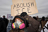 A demonstrator wearing a mask holds a sign reading 'Abolish ICE' as she takes part in a protest outside the Whipple Federal Building, more than a week after a U.S. Immigration and Customs Enforcement (ICE) agent fatally shot Renee Nicole Good on Jan. 7, in Minneapolis, Minnesota, Jan. 15. [REUTERS/YONHAP]