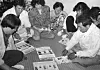 Parents of the missing Frog Boys look at flyers of their sons in an undated photo. [JOONGANG ILBO]