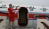 An undated image of a North Korean flight attendant pointing to a North Korean plane, posted on Koryo Tours' website [SCREEN CAPTURE]