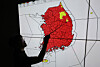 This file photo shows a weather agency official pointing to a map of Korea, with areas under a special heat wave advisory marked in red across most of the country on July 30. [YONHAP]