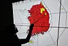 This file photo shows a weather agency official pointing to a map of Korea, with areas under a special heat wave advisory marked in red across most of the country on July 30. [YONHAP]