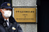 A Japanese police officer stands guard next to a plaque at the entrance of the Chinese embassy in Tokyo on Nov. 18. [REUTERS/YONHAP]