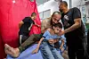 A man embraces an injured boy as they sit on a bed at the trauma ward of al-Awda Hospital in the Nuseirat camp for Palestinian refugees in the central Gaza Strip on July 6. [AFP/YONHAP]