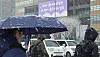 Pedestrians cross a road by Gwanghwamun Square in Jongno District, central Seoul, as heavy snow advisories were issued across the country on March 18. [YONHAP]