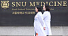 Doctors walk across the Seoul National University College of Medicine campus in Jongno District, central Seoul, on March 27. [NEWS1]