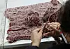 A woman knits a vest at a recycling center in Eungam-dong, northern Seoul, on Jan. 17, 2022. [JOONGANG ILBO]