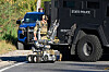 A Michigan State Trooper stands with a robot along East Atherton Road near the home of a suspect allegedly involved in a shooting at The Church of Jesus Christ of Latter-day Saints, Sept. 28, in Burton, Mich. [AP/YONHAP]