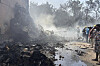 People stand around debris at the site of an airplane that crashed in India's northwestern city of Ahmedabad in Gujarat state on June 12. [AP/YONHAP]