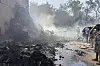 People stand around debris at the site of an airplane that crashed in India's northwestern city of Ahmedabad in Gujarat state on June 12. [AP/YONHAP]