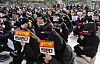 Dongduk Women's University students hold signs that read they are against becoming a coed institution at the university campus in Seongbuk District, northern Seoul, on Dec. 11. [YONHAP]