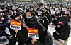 Dongduk Women's University students hold signs that read they are against becoming a coed institution at the university campus in Seongbuk District, northern Seoul, on Dec. 11. [YONHAP]