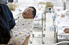 A nurse picks up a newborn baby at a hospital in western Seoul on Feb. 26. [JUN MIN-KYU]