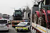 Police cars surround trucks with tractors loaded in the back in Gangnam District, southern Seoul, on March 25. The trucks are driven by members of the Korean Peasants League protesting for the impeachment of President Yoon Suk Yeol. [YONHAP]