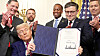 U.S. President Donald Trump shows a signed resolution approved by Congress to rescind the EPA's 2023 approval of California's plans to require a rising number of zero-emission heavy-duty trucks, and another resolution on California's low-NOx, or low-nitrogen oxide, regulation for heavy-duty highway and off-road vehicles and engines, at the White House in Washington on June 12. [REUTERS/YONHAP]