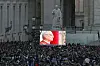 People watch as newly elected Pope Leo XIV, Cardinal Robert Prevost of Unites States, shown on screen, appears on the balcony of St. Peter's Basilica, as seen from Rome, Italy on May 8. [REUTERS/YONHAP]