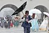 A child visiting Gyeongbokgung Palace in Jongno District, central Seoul, avoids rain with flipped umbrella on July 22. [NEWS1]