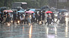Citizens walk across a street in Jongno District, central Seoul on Aug. 13 as heavy rainfalls swept the central regions of the country. [YONHAP]