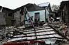 Men look for belongings in front of their house damaged by storm surges after Typhoon Fung-wong hit the coast of Alacan, Pangasinan, Philippines, Nov. 11, 2025. [REUTERS/YONHAP]