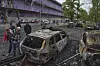 People look at their burnt cars in the residential area following Russia's drone attack in Kyiv, Ukraine, on May 4, 2025. [AP/YONHAP]