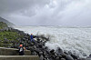 People watch as strong waves batter Basco, Batanes province, northern Philippines as Typhoon Ragasa affects the area on Sept. 22. [AP/YONHAP]