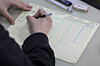 A student fills in answers on an OMR card. [JOINT PRESS CORPS]