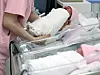 A newborn baby is being picked up by a nurse at a hospital in western Seoul on May 28. [NEWS1]