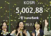 Korean bourse Kospi surpasses the 5,000 mark for the first time on the morning of Jan. 22. Numbers are shown at a digital board in Hana Bank in Jung District, central Seoul, as dealers celebrate the historic moment. [YONHAP]