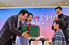 President Lee Jae Myung, left, and first lady Kim Hea Kyung, second from left, give a present to a patient at Severance Hospital in Seoul on Dec. 24. [YONHAP]