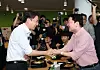 Reform Party candidate Lee Jun-seok, left, shakes hands with Rep. Ahn Cheol-soo, co-chair of the People Power Party's election committee, at a cafeteria inside the campus of Gachon University in Seongnam, Gyeonggi, on May 21. [NEWS1]
