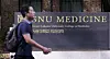 A pedestrian walks past the signboard of Seoul National University's College of Medicine in central Seoul on Monday, a day after the Ministry of Education conditionally allowed medical schools to process students' leave requests. [NEWS1]