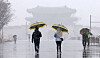 People with umbrellas walk across Gwanghwamun Square in Jongno District, central Seoul, amid heavy snow on March 4. [NEWS1]