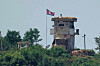 A soldier stands at a North Korean military guard post flying a national flag, seen from Paju, Gyeonggi on June 26, 2024. [AP/YONHAP]