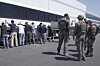 This image from video provided by U.S. Immigration and Customs Enforcement via Dvids shows manufacturing plant employees waiting to have their legs shackled at the Hyundai Motor Group’s electric vehicle plant on Sept. 4 in Ellabell, Georgia. [AP/YONHAP]