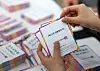Staff at the National Election Commission in Gwacheon, Gyeonggi, organize identification tags for election officials on April 14. [YONHAP]