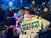 A protester holds a light stick and a placard supporting President Yoon Suk Yeol's arrest in Jongno District, central Seoul on Dec. 24. [JANG SEO-YUN]