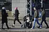 People walk past a street musician in the center of Helsinki, Finland, on March 15. [AP/YONHAP]